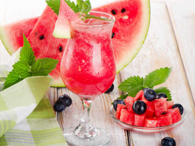 Арбузный сок со льдом в бокале со свежим арбузом и ягодами черники