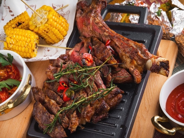 Запеченное мясо с кукурузой и кетчупом на столе