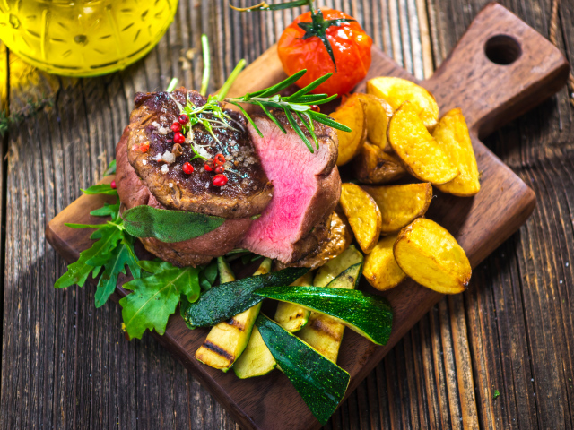 Сочный кусок мяса с картофелем, кабачками и помидорами