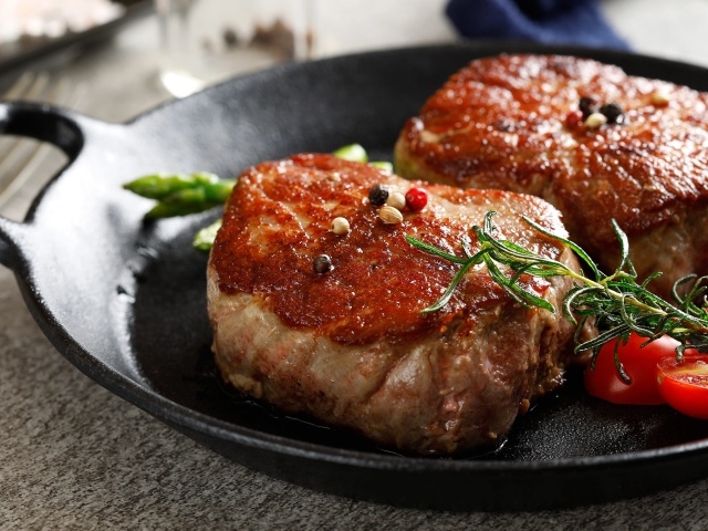 Два аппетитных сочных куска мяса с помидорами и розмарином