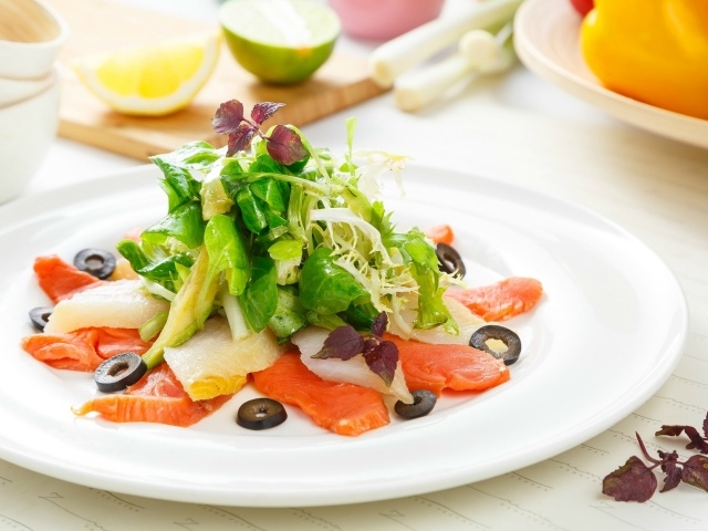 Аппетитный салат с морепродуктами на белой тарелке 