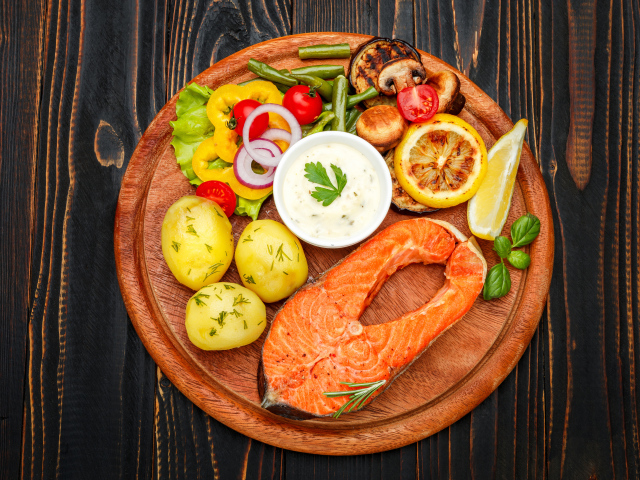 Жареный кусок рыбы с овощами и соусом