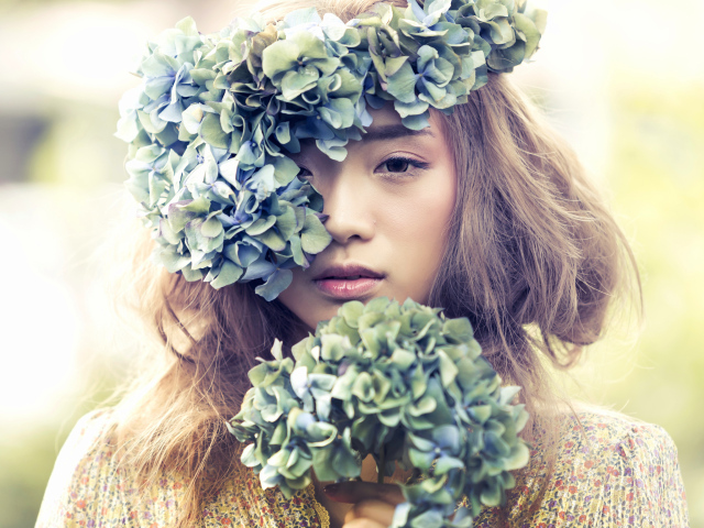 Молодая девушка азиатка с венком из цветов на голове