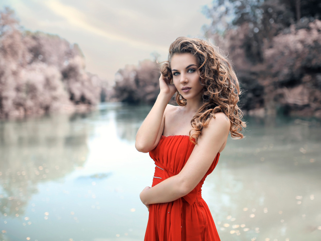 Красивая девушка брюнетка в красном платье у водоема