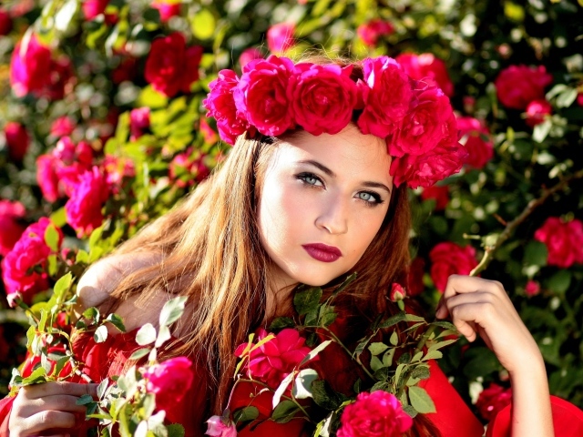 Красивая девушка с венком из красных роз на голове 