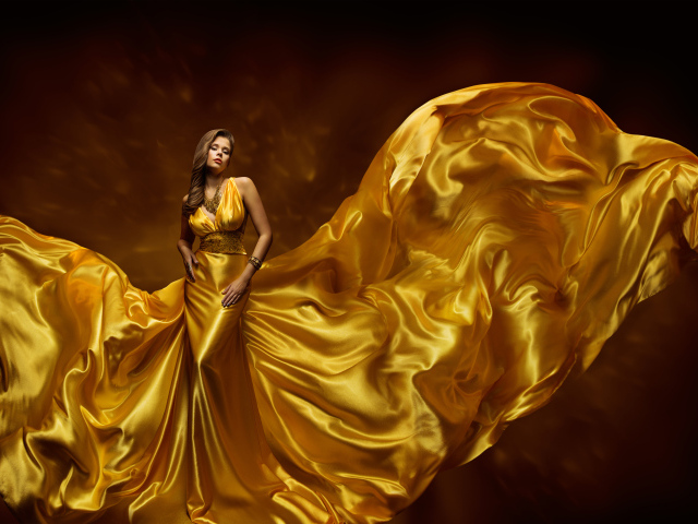 Красивая девушка шатенка в красивом платье золотого цвета