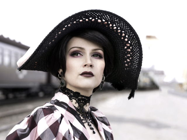 Красивая зеленоглазая девушка в большой черной шляпе