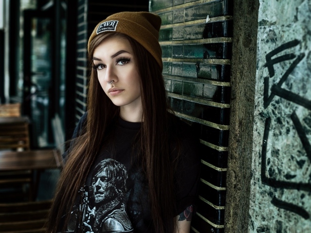 Красивая молодая девушка в шапке с пирсингом в носу