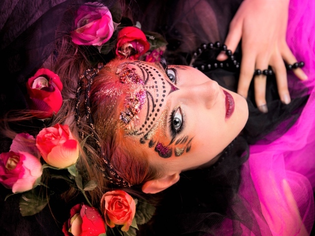 Девушка с блестящим ярким макияжем и розами в волосах