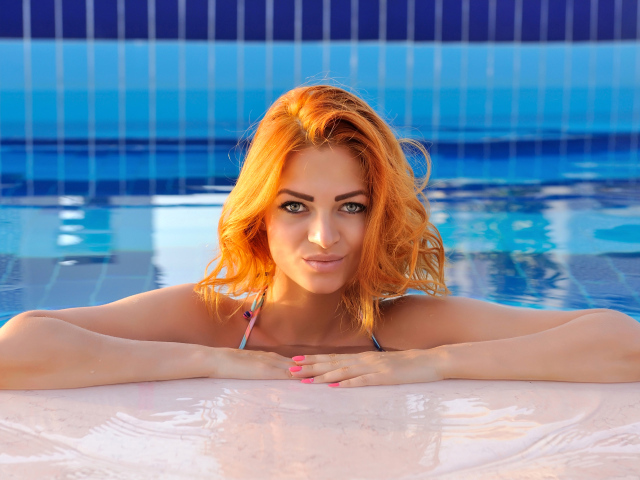 Эффектная рыжеволосая девушка в бассейне