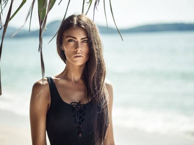 Стильная брюнетка с длинными волосами на пляже