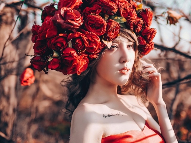 Молодая девушка азиатка с красными цветами на голове