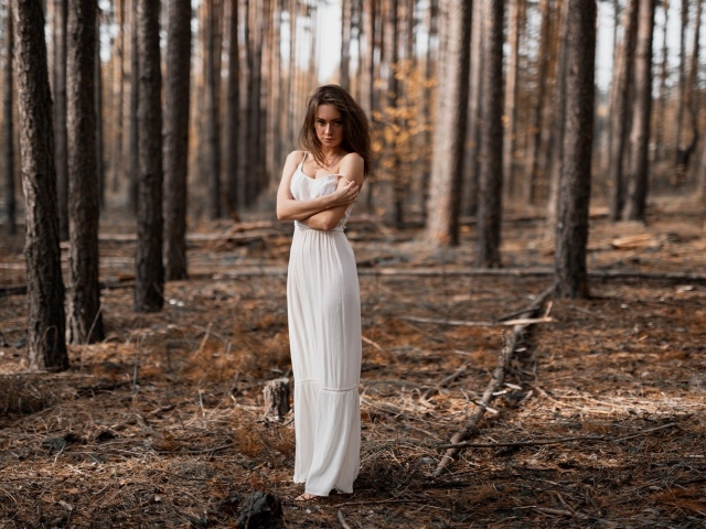 Молодая девушка в белом платье в лесу 