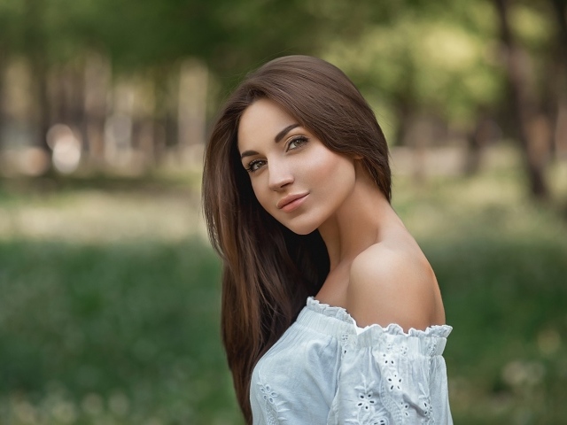 Молодая девушка с длинными волосами в белом 