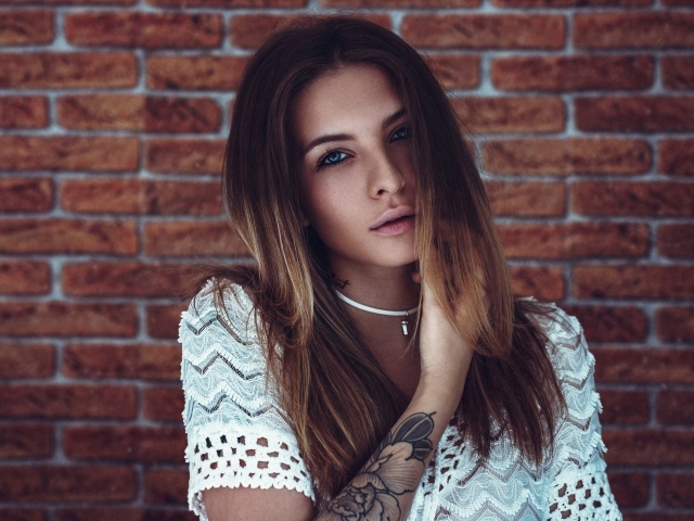 Молодая девушка с татуировкой на руке