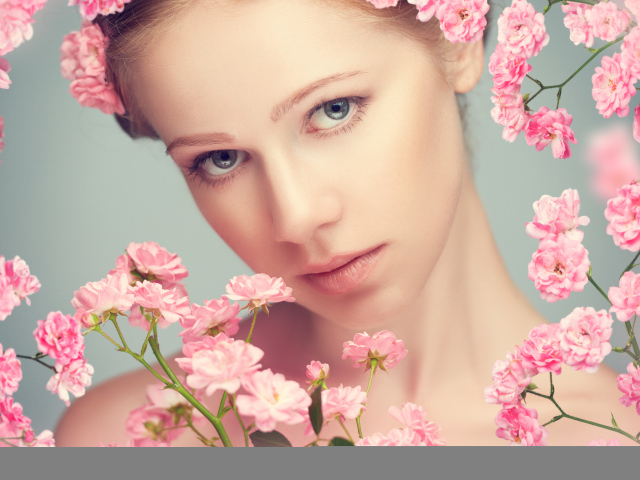 Молодая нежная девушка с розовыми розами на сером фоне