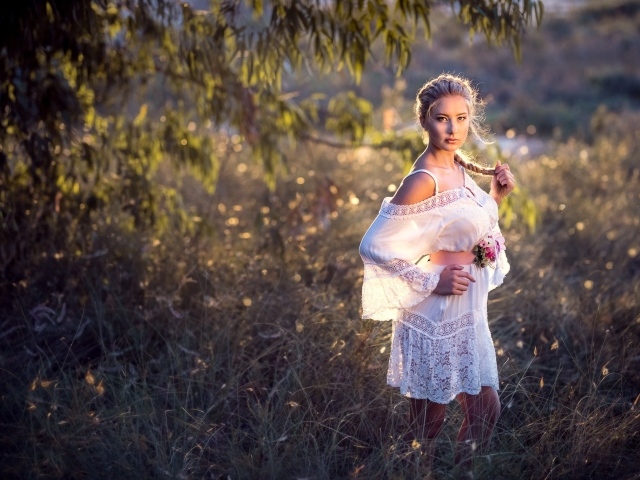 Молодая девушка модель в красивом белом платье с косой на голове