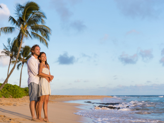 Влюбленная пара встречает закат на берегу океана