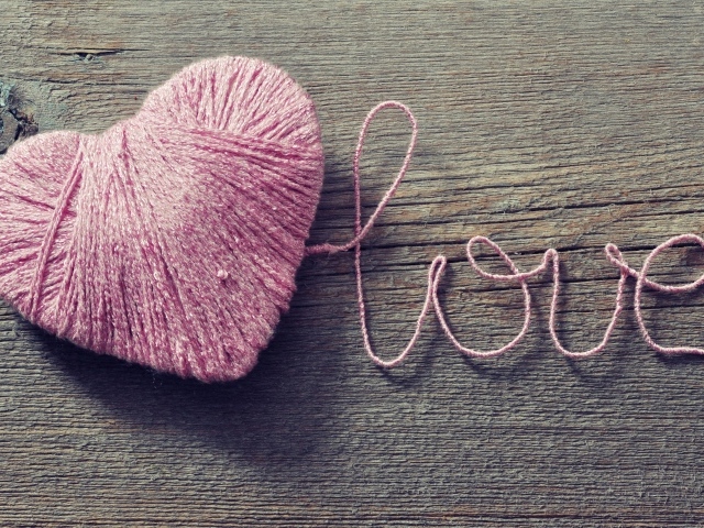 Надпись Love из розовых ниток на деревянном столе