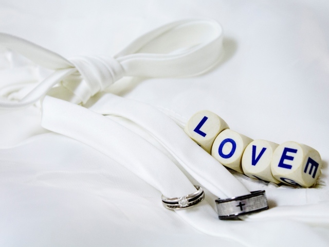 Два кольца перевязанные белой лентой и кубики с надписью любовь