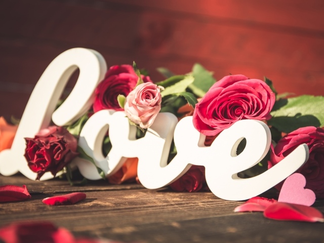 Белая надпись любовь с букетом роз