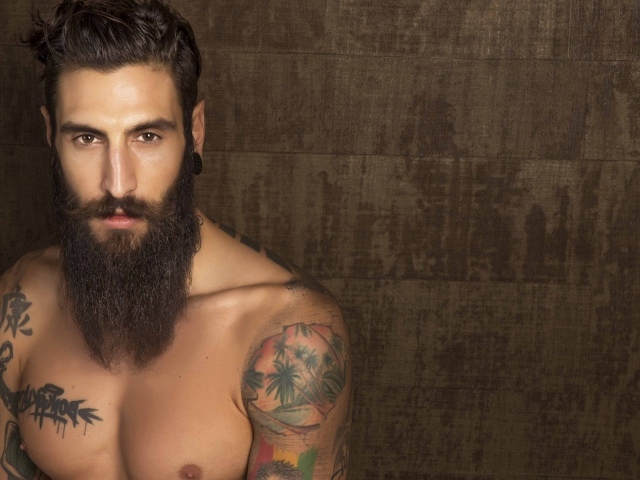Молодой парень модель Маттео Маринелли с бородой и татуировками на теле