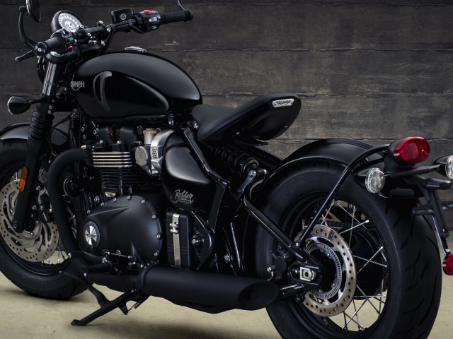 Черный мотоцикл Triumph Bonneville Bobber, 2018 вид сзади