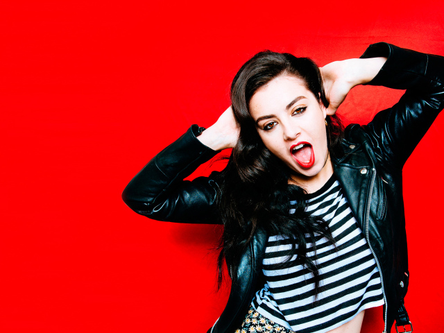 Американская певица Charli XCX позирует на красном фоне 