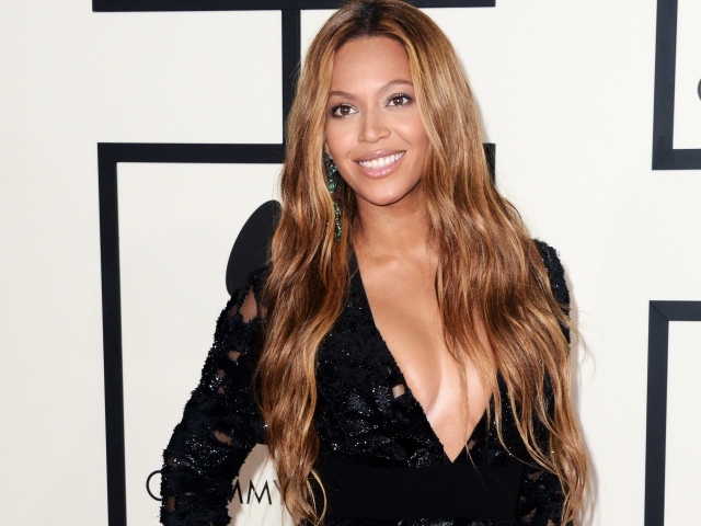 Красивая улыбающаяся певица Бейонсе в черном платье