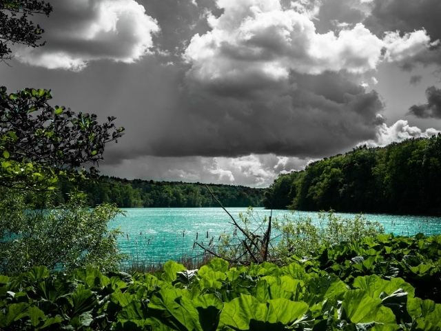 Голубая вода в озере на фоне дождевых облаков 