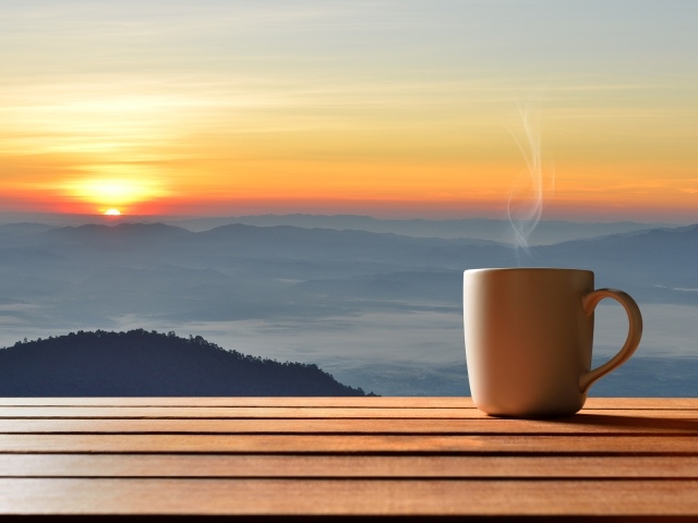 Чашка фоне на фоне горизонта с восходящим солнцем