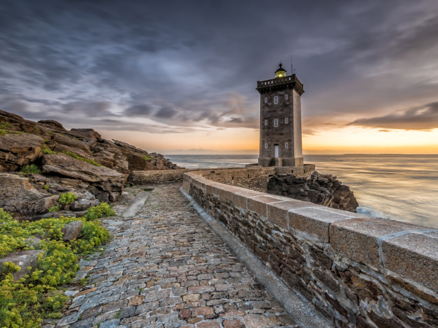 Маяк на берегу океана под красивым небом