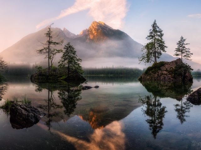 Горное озеро у покрытых туманом гор 