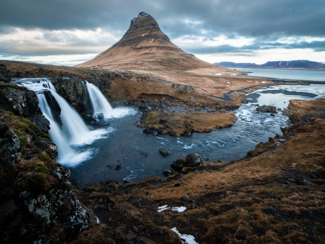 Гора и водопад у реки в Исландии  
