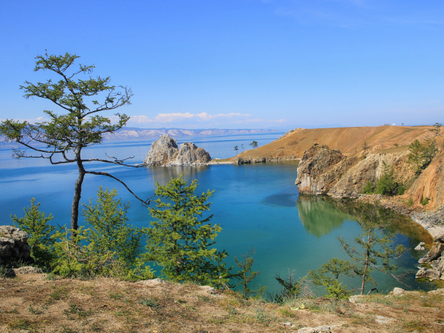 Каменные утесы у чистой воды живописного озера Байкал,  Россия