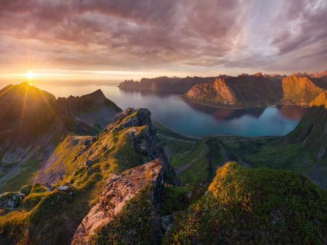 Восход солнца в красивом небе над покрытыми зеленью горами 