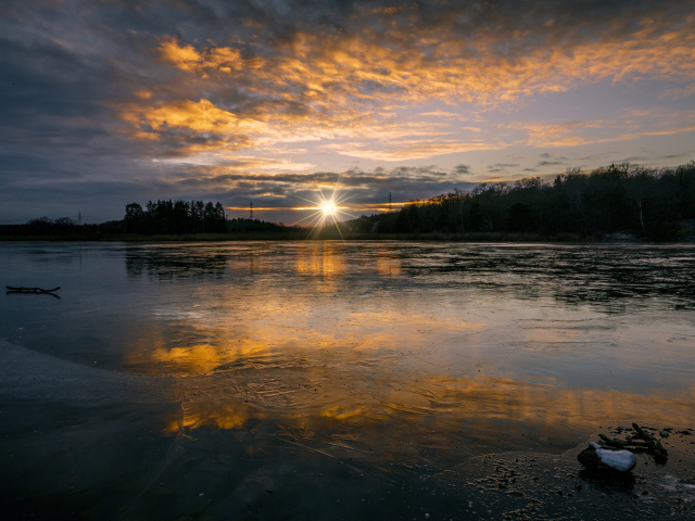 Рассвет холодного солнца над заледеневшим озером