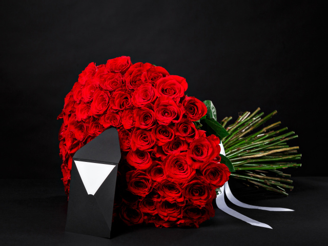 Большой букет красных роз с конвертом на черном фоне