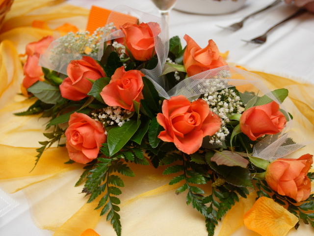 Красивый букет оранжевых роз с зелеными листьями