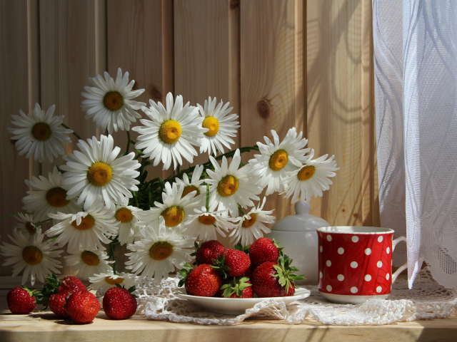 Букет белых ромашек на столе с клубникой