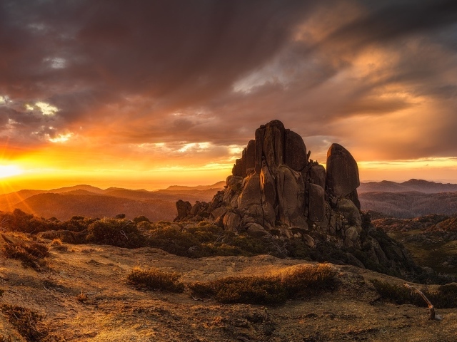 Скала в лучах восходящего солнца 