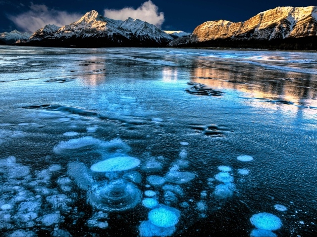 Покрытое льдом чистое  озеро Эйбрахам на фоне гор, Канада