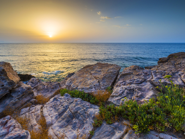 Каменные скалы на закате солнца над Средиземным морем, Греция