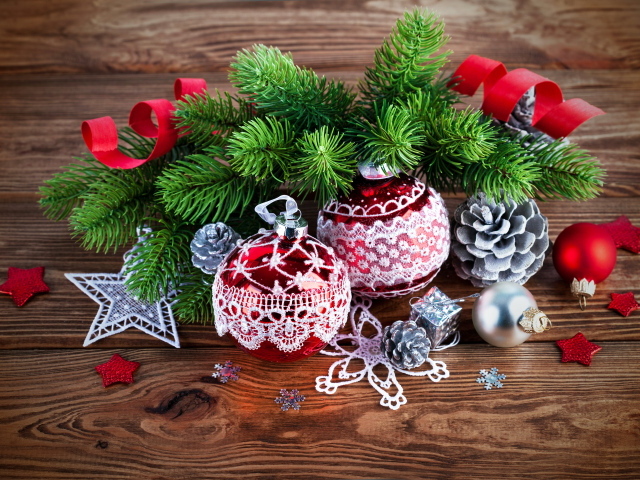Красивые елочные игрушки с зеленой еловой веткой на деревянном столе 