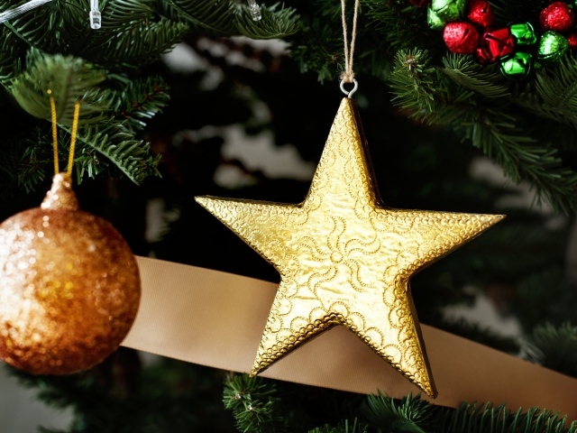 Золотая звезда и шар на новогодней елке