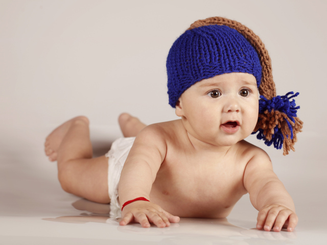 Грудной кареглазый ребенок в вязаной шерстяной шапке