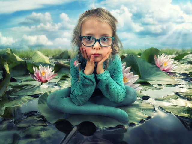 Маленькая девочка в зеленом костюме сидит на листе водяной лилии