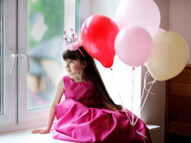 Маленькая девочка в костюме принцессы сидит на окне