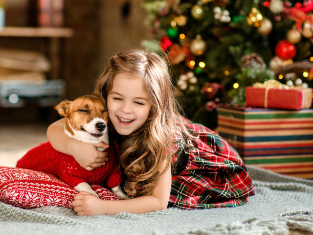 Маленькая девочка с собакой радуются новому году