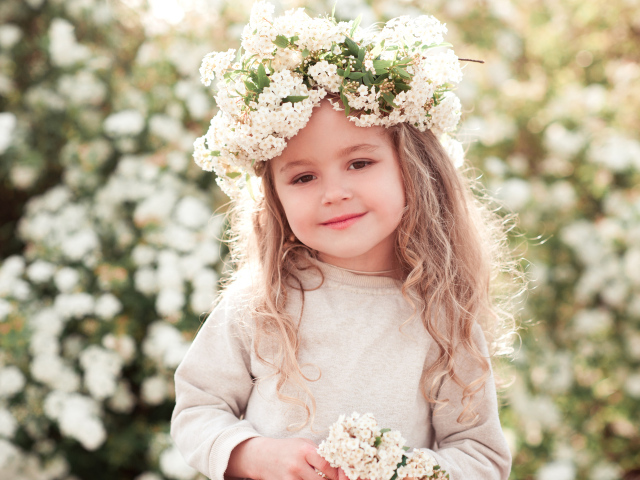 Маленькая девочка с венком из белых цветов на голове